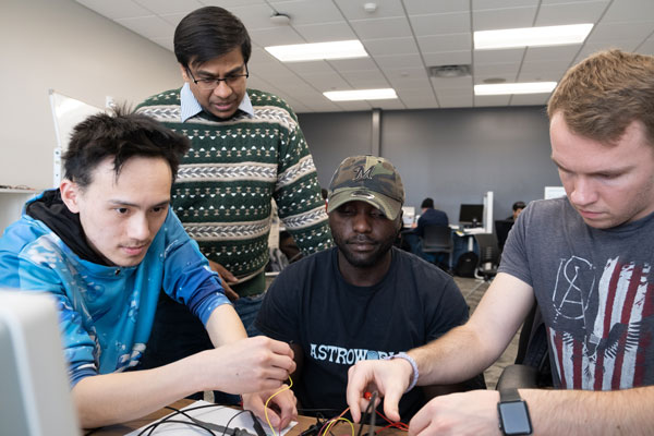 UW Green Bay professor helps group of students in class