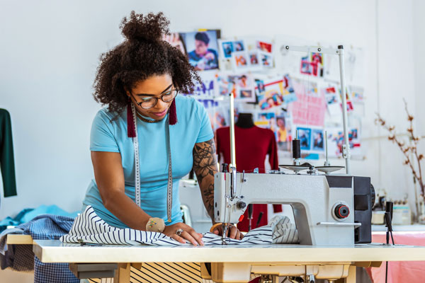 African American female works at sewing machine