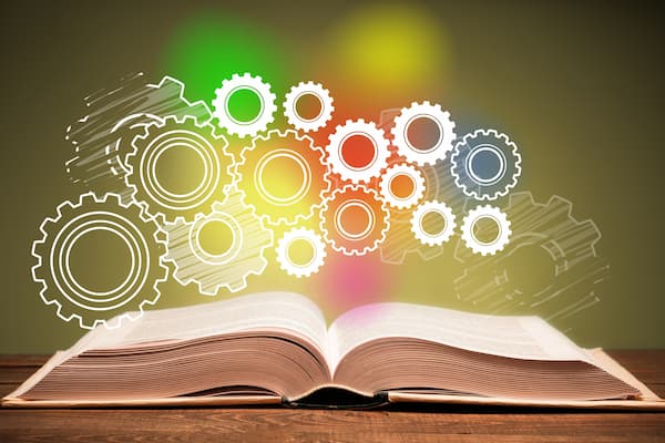 Open book with illustration of gears floating above