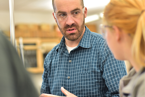 A professor talking to a student in a science lab.