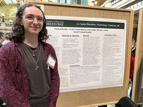 Student standing by project