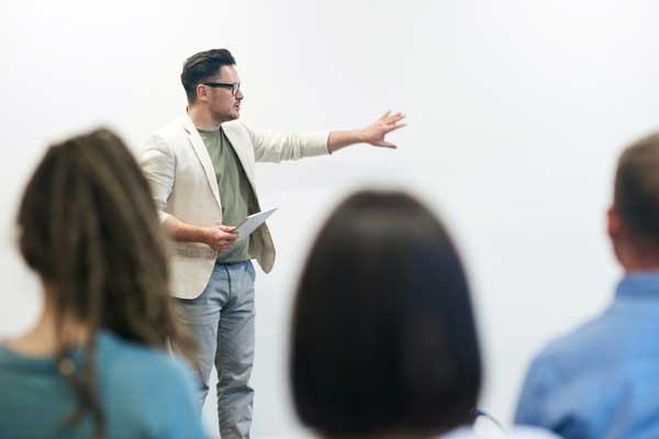 Employees listen to coworker presentation