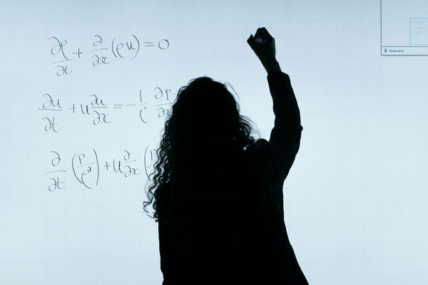 Teaching showing mathematical equations on whiteboard