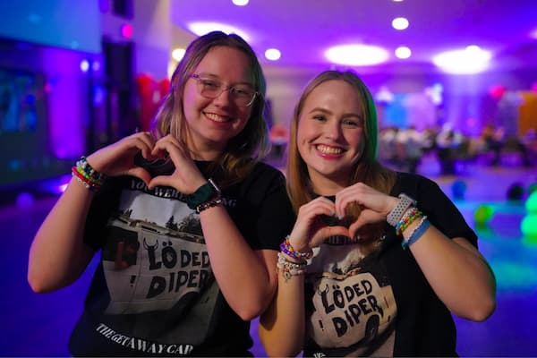 Two girls form heart with hands