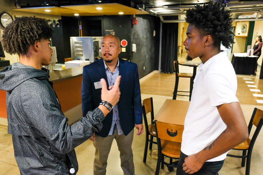 African American students talking with business professional