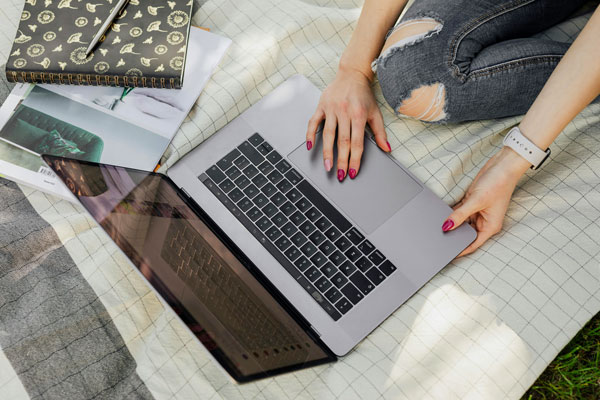 Female sitting on the ground using laptop