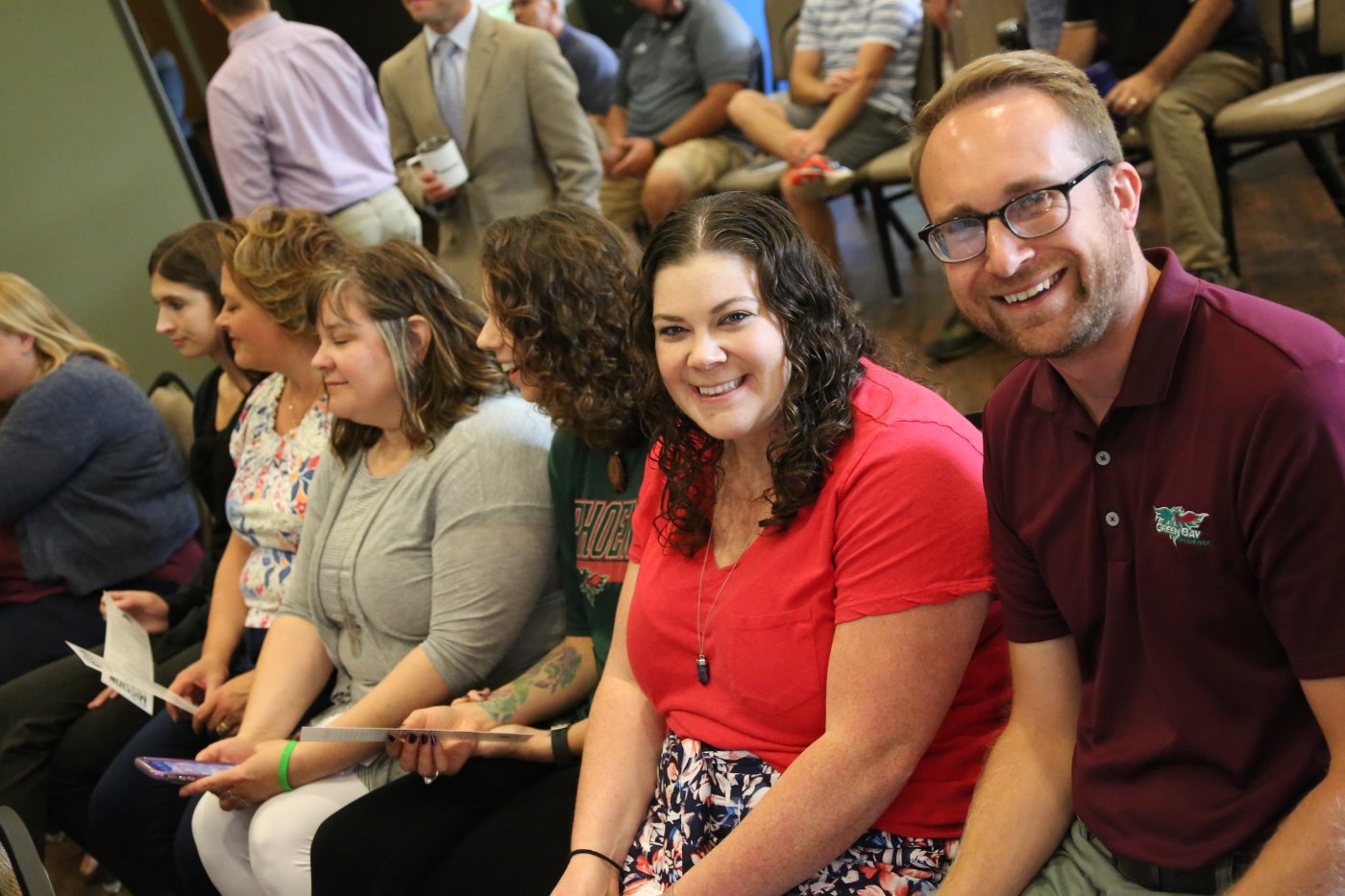 smiling staff seated at a university event