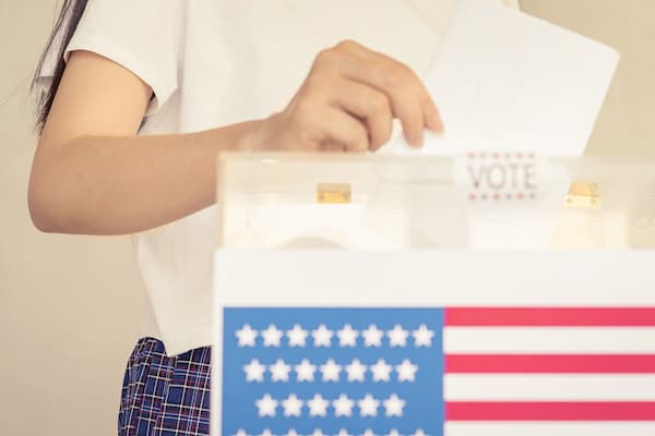 Person places ballot in voting box