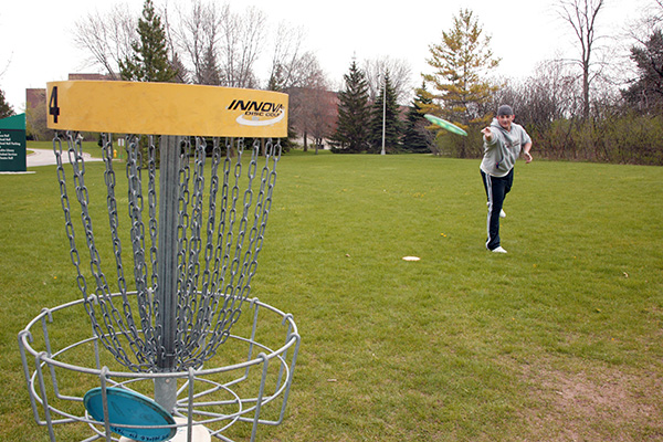 Man playing disc golf on the uwgb campus