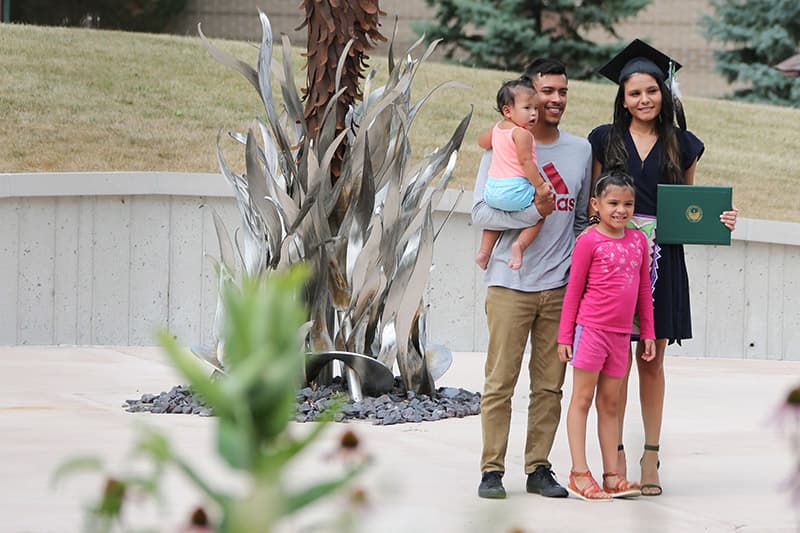 Graduate holding diploma with family