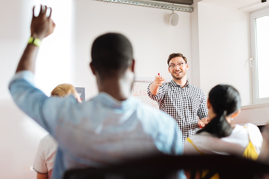 trainer pointing at a student raising his hand