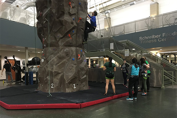 Climbers and belayers at the bottom of the uwgb indoor climbing tower