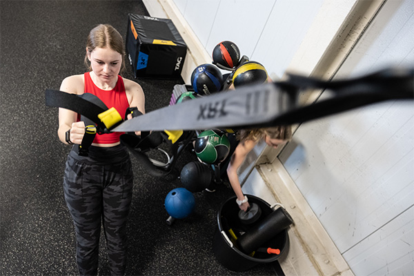 student training with TRX bands in the uwgb fitness center