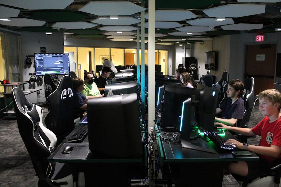 students coding video games with large screen