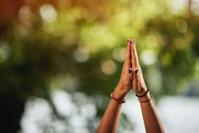 hands with palms together reaching for sky spiritual journey concept