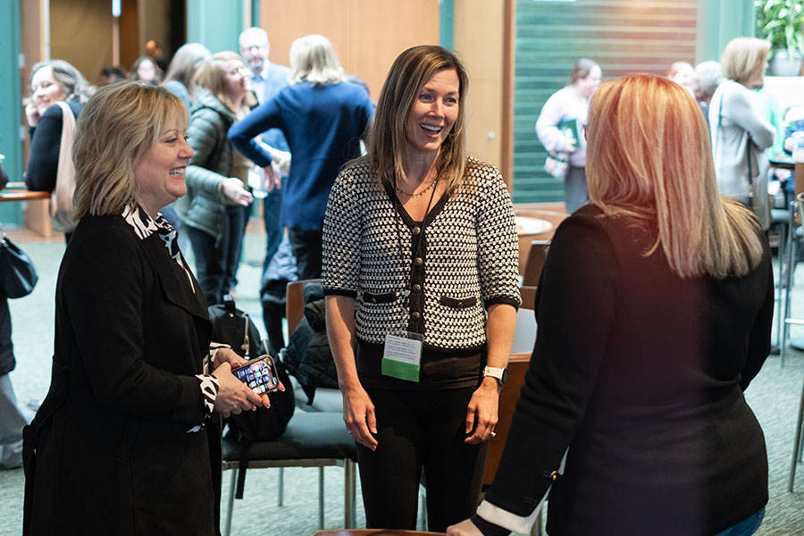 three women talking at an event